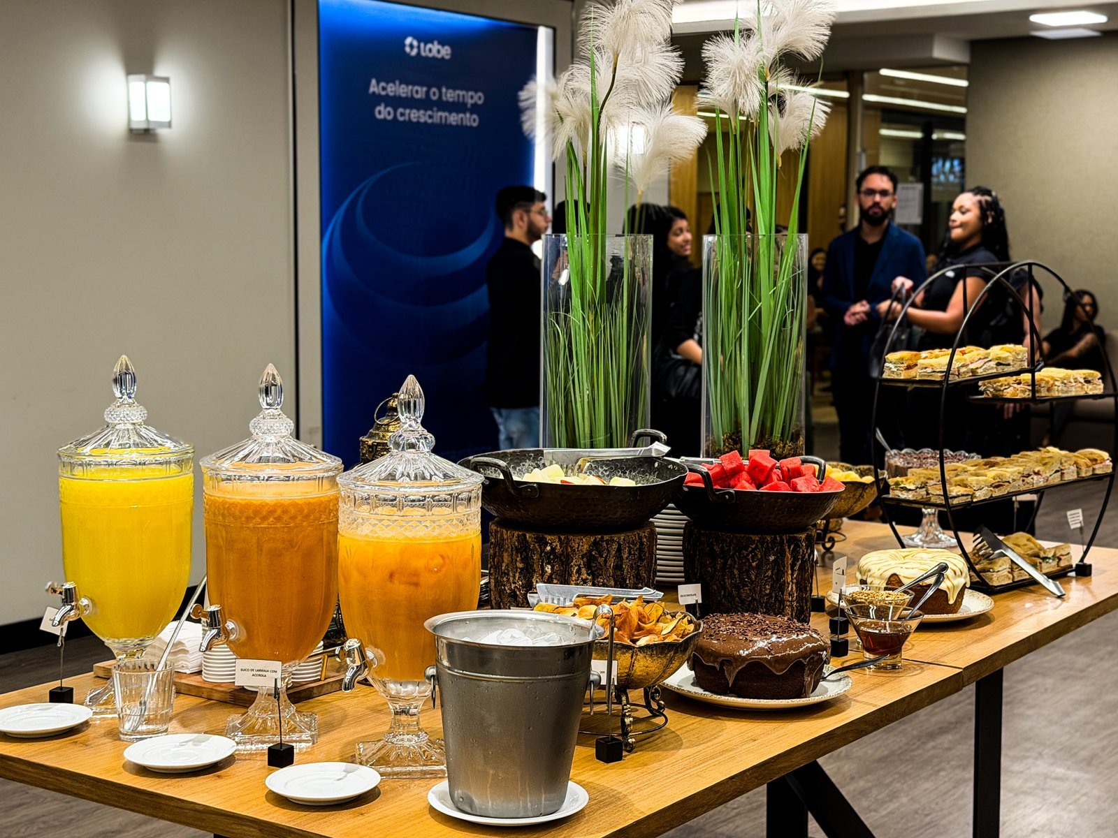 Coffee break com banner institucional ao fundo