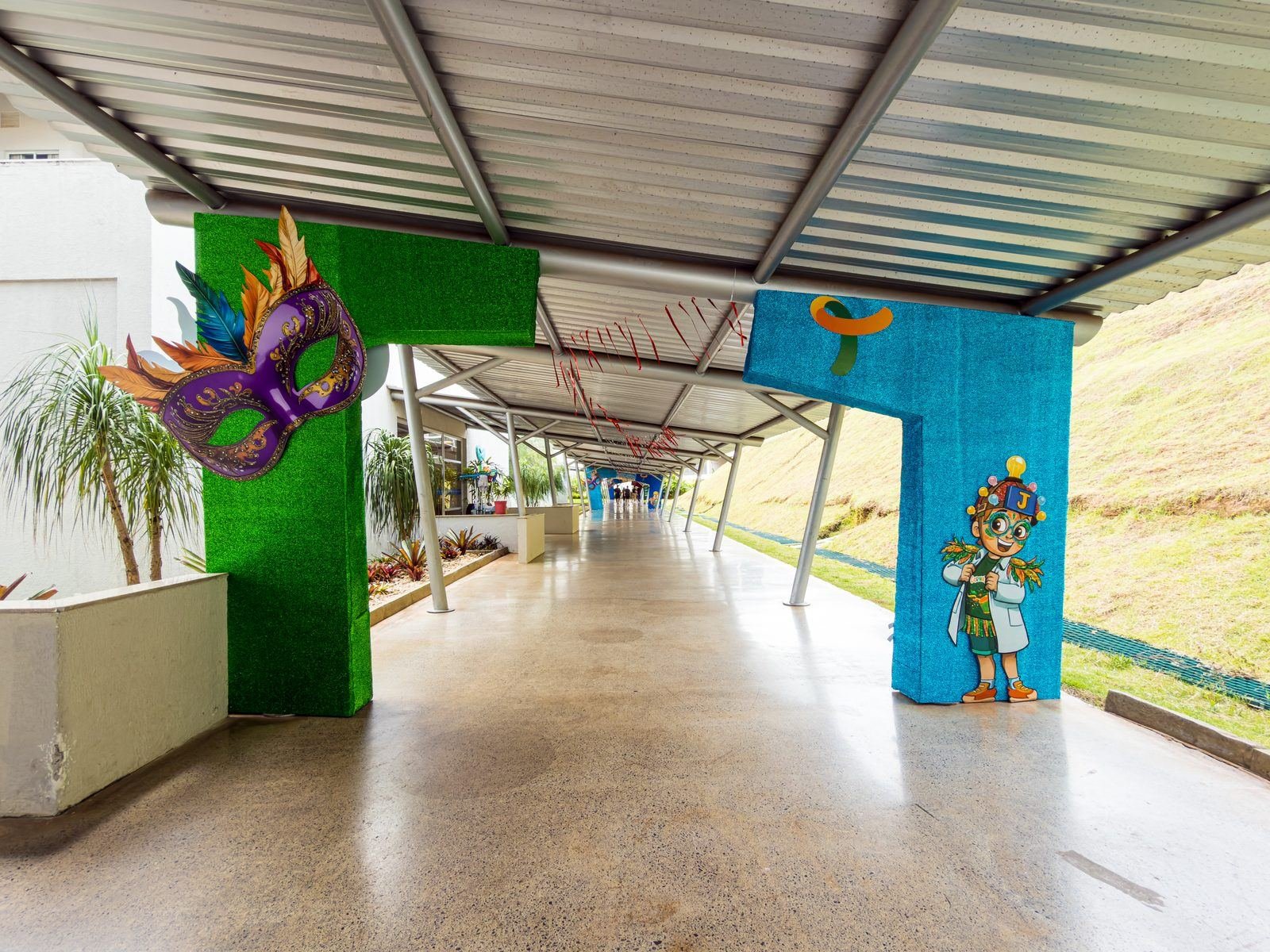 Pórticos externos com máscara carnavalesca no corredor coberto